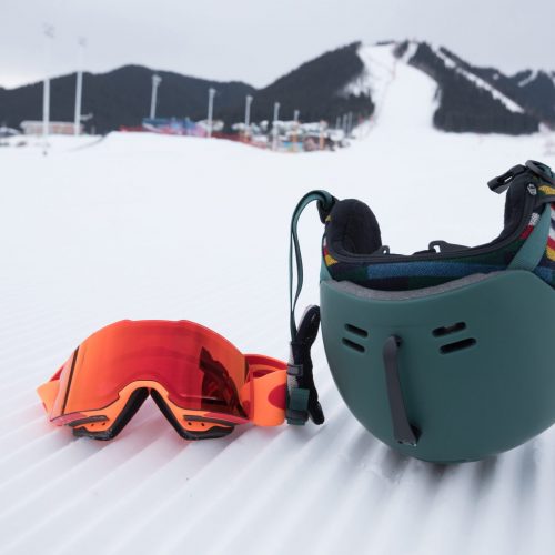 snowboard goggles and helmet on ski piste slop